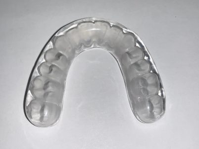 Clear dental night guard on white background